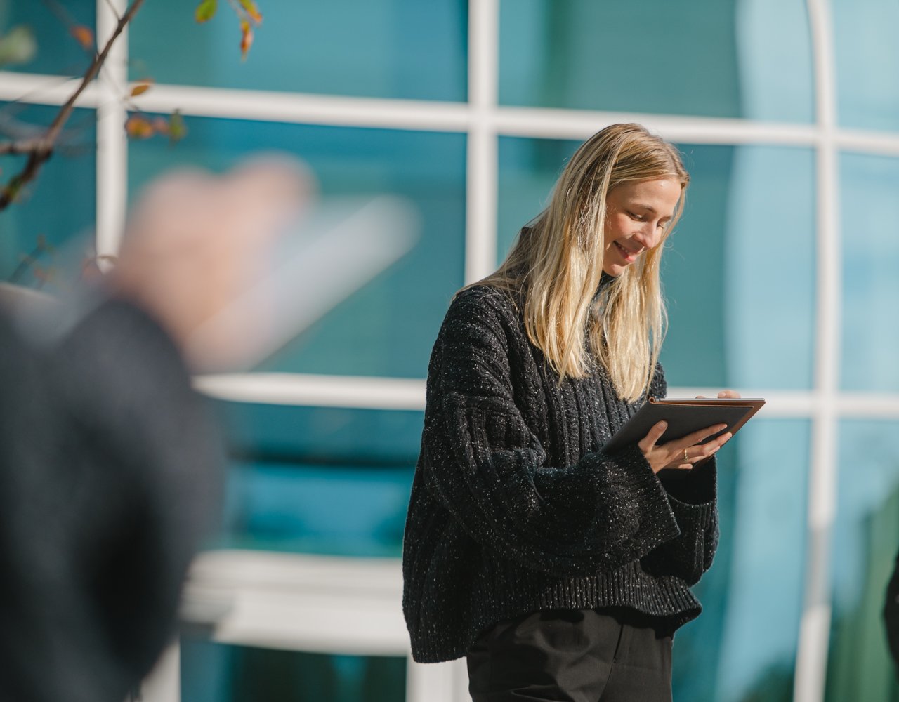 Bilde av en dame som ser ned og holder en ipad