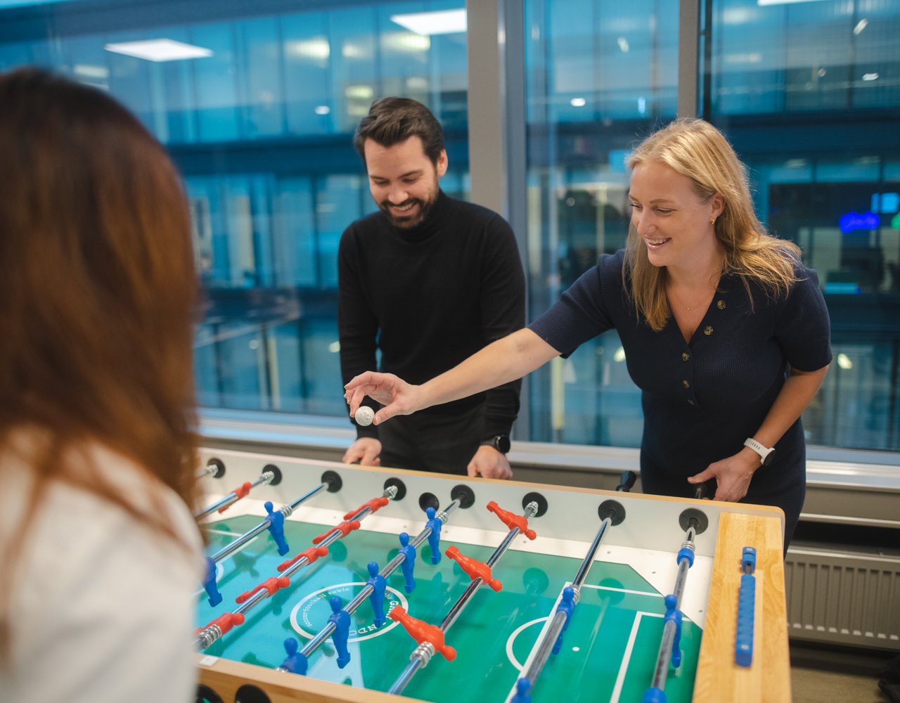 Tre kollegaer som spiller fotballspill på kontoret